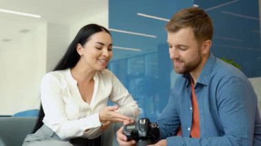 Photographer and model watch photos sitting in the business center.