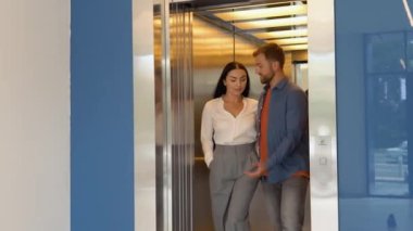 Confident business partners talking leaving the elevator.