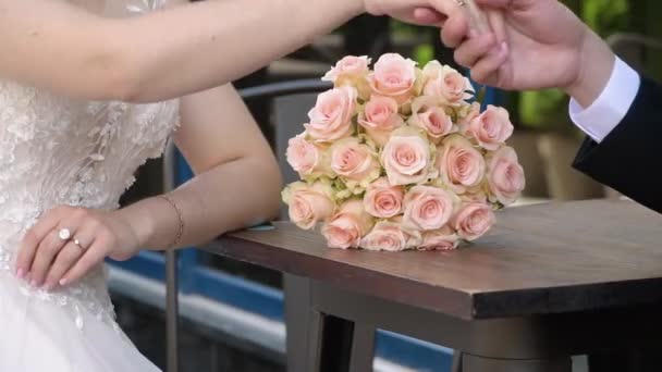 Жених Невеста День Свадьбы Сидят Столом Свадебным Букетом — стоковое видео