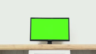 Chroma key screen for advertising. LcD smart TV screen with a blank green background in the living room.