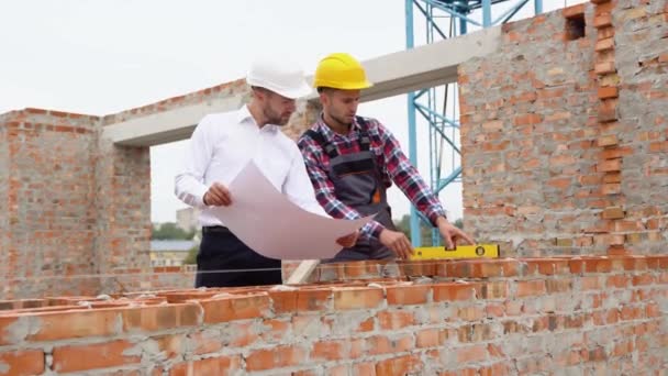 Två Byggnadsarbetare Tittar Arkitektonisk Ritning Husbyggnad — Stockvideo