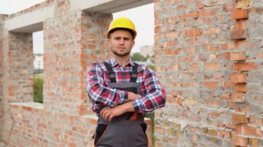 Kask ve site bina yelek ile memnun ve kendine güvenen mühendis portresi