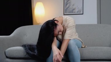 Depresyondaki kadın dizine sarılıp ağlar. Üzgün kadın boş bir odada tek başına oturuyor..