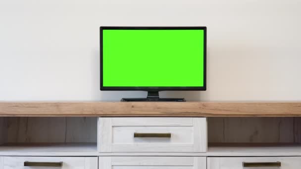 テレビスタンドに立って緑の画面モックアップディスプレイとテレビセットでスタイリッシュなロフトアパートメントインテリア モニター上のクロマキープレースホルダと自宅で空のリビングルーム ズームオンショット — ストック動画