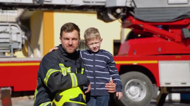 Portré Egy Tűzoltóról Cuki Fiúval Karján Életmentés Tűzbiztonság — Stock videók