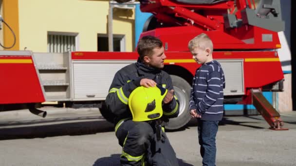 Liten Pojke Med Brandman Skyddsuniform Brandstationen Begreppet Rädda Liv Brandsäkerhet — Stockvideo