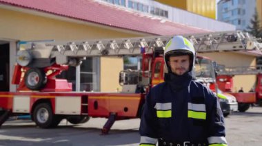 İtfaiye arabasının yanında miğferi olan itfaiyeci portresi. Görevdeki itfaiyeci portresi