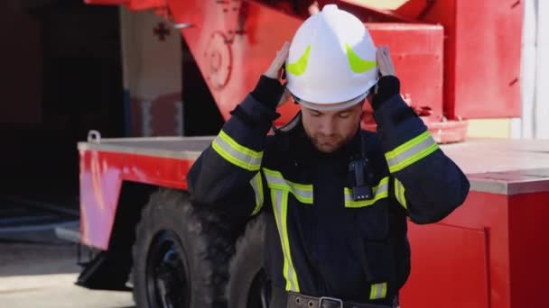 Retrato Del Guapo Bombero Traje Equipado Pone Casco Mirando Cámara — Vídeo de stock