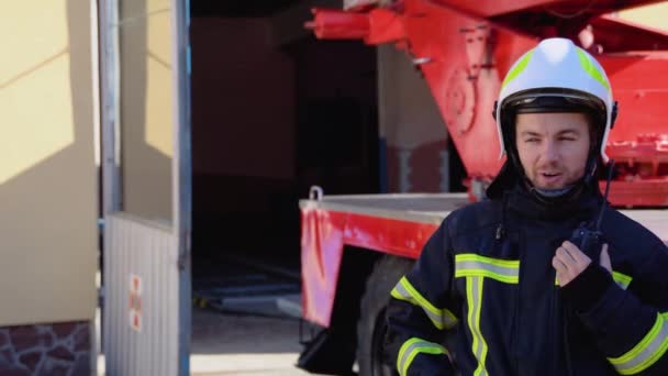 Mutiger Feuerwehrmann Gespräch Mit Walkie Talkie Mit Feuerwehrauto Hintergrund — Stockvideo