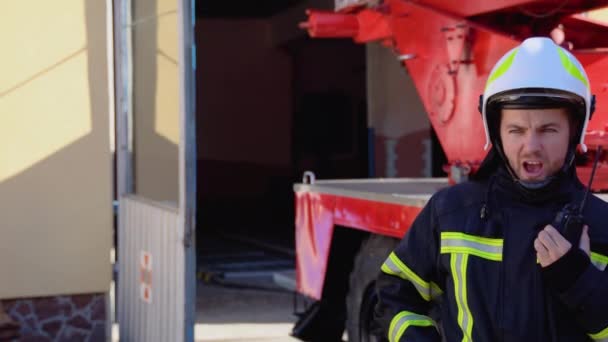 Mutiger Feuerwehrmann Gespräch Mit Walkie Talkie Mit Feuerwehrauto Hintergrund — Stockvideo