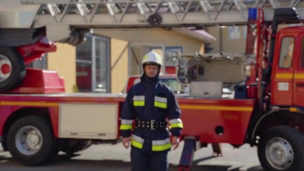 Kaukasischer Feuerwehrmann Mit Helm Und Voller Ausrüstung Tritt Lächelnd Vor — Stockvideo