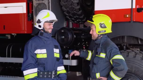 Dois Bombeiros Roupas Protetoras Capacetes Com Motor Incêndio Aperto Mão — Vídeo de Stock