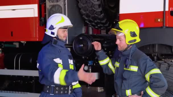 Dois Bombeiros Roupas Protetoras Capacetes Com Motor Incêndio Aperto Mão — Vídeo de Stock