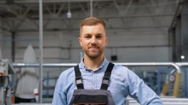 Üniformalı işçinin portresi bir kask takıyor ve kameraya bakıyor..