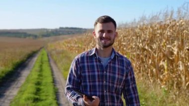 Kafkasyalı tarım işçisi mısır tarlasında teftiş için yürüyor. Hasat bakım konsepti