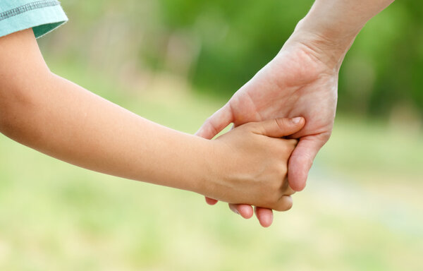 Mother holding a hand of her son