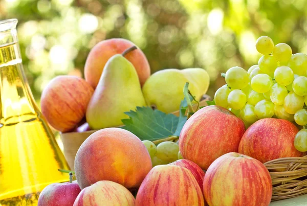 Organic fruits and white wine on table — Stock Photo, Image