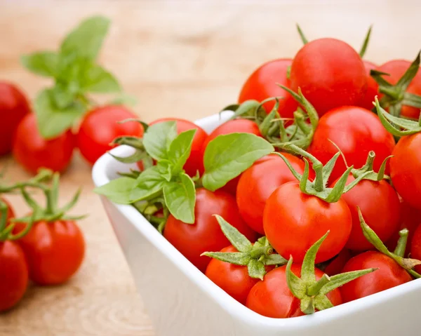 Tomate cereja na tigela na mesa — Fotografia de Stock