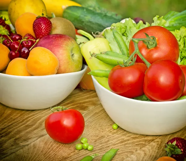 Organic fruits and vegetables in a bowls — Stock Photo, Image