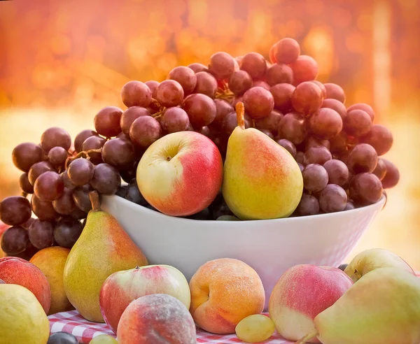 Färska ekologiska frukter i skål på bordet — Stockfoto