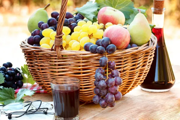 Trauben im Weidenkorb und Rotwein — Stockfoto