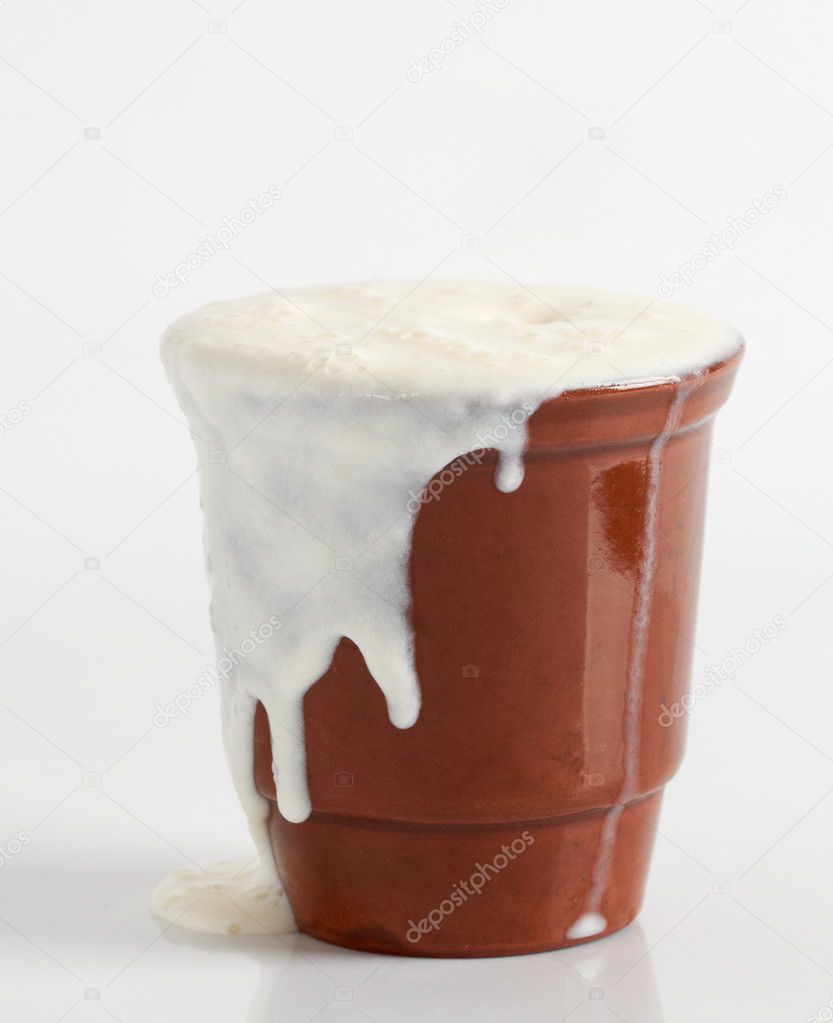 Curdled milk poured from a clay cup