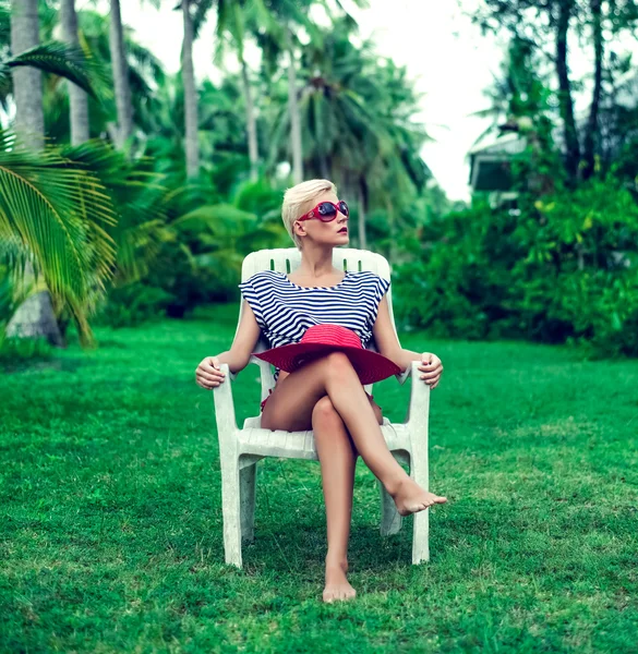 Oturan moda kız parkta bir sandalyede oturan — Stok fotoğraf
