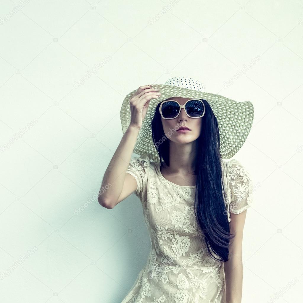 fashion portrait of a sensual girl in a hat against the wall