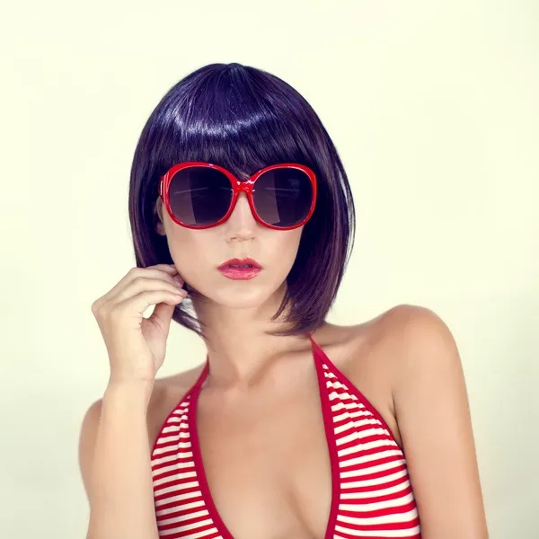 Portrait of a girl in a fashionable swimsuit and sunglasses — Stock Photo, Image