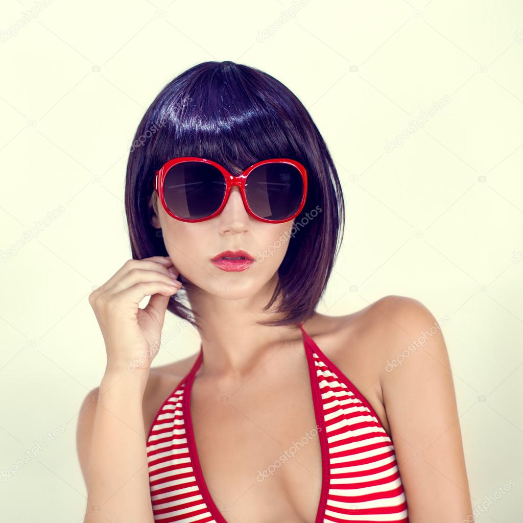 Portrait of a girl in a fashionable swimsuit and sunglasses