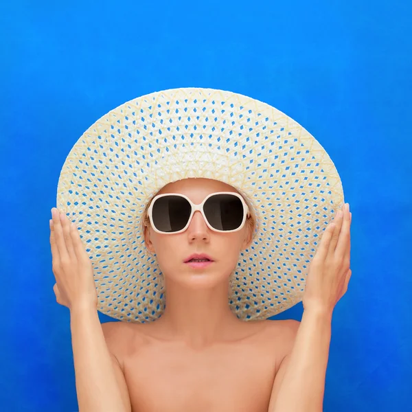 Portrait d'une fille dans un chapeau sur un fond bleu — Photo