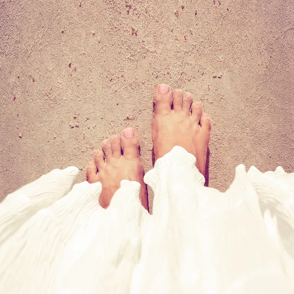 Vrouw voeten close-up ontspannen op het strand — Stockfoto