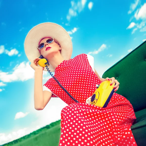 Fashion portrait of a girl in a retro style with a phone