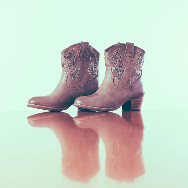Botas de cowboy com reflexão no chão de madeira — Fotografia de Stock