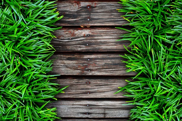 Hierba verde sobre fondo de madera . — Foto de Stock
