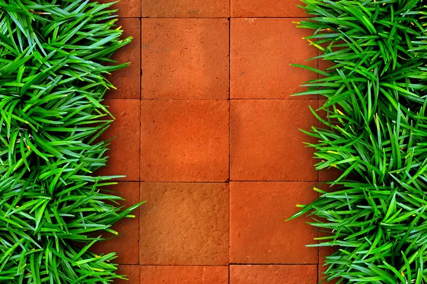 Gras en rode baksteen achtergrond. — Stockfoto
