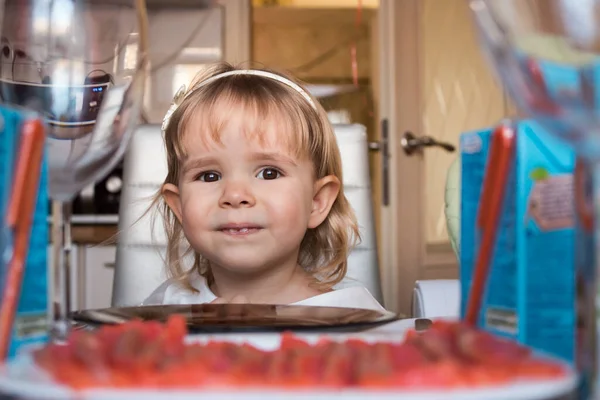 Little girl celebrates a birthday, head close on the background of a festive table — Stock Photo, Image