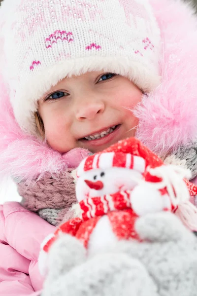 Ребенок со снеговиком зимой — стоковое фото