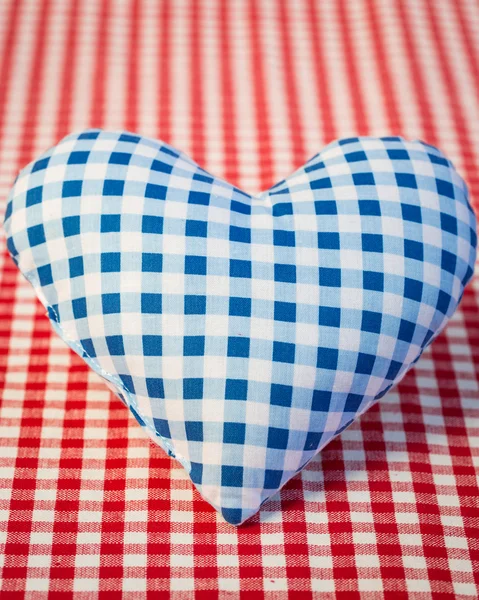 Corazón azul sobre mantel de gingham — Foto de Stock