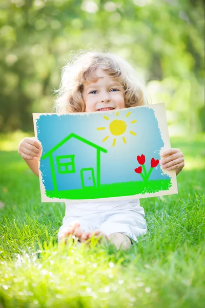 Child holding drawn spring landscape — Stock Photo, Image