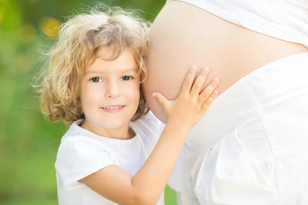 Niño feliz abraza el vientre — Foto de Stock