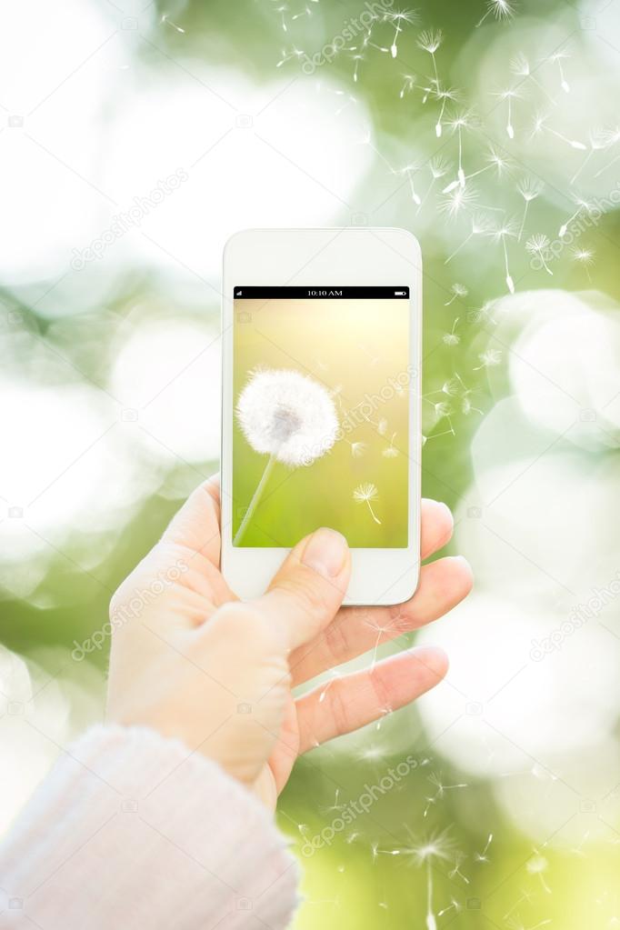 Woman holding smartphone with flower