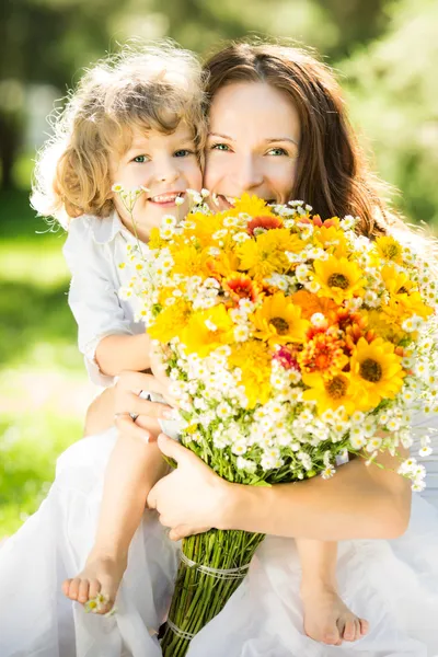 Familia feliz con flores de primavera —  Fotos de Stock