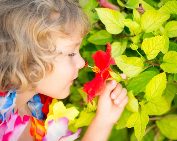 Bambino con fiore tropicale — Foto Stock