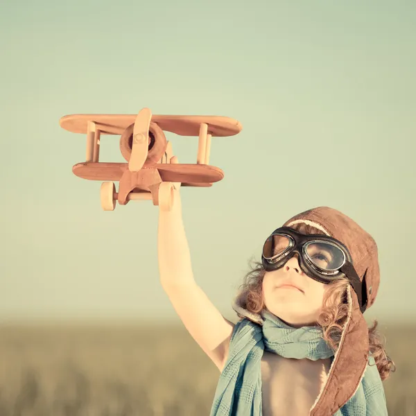 Szczęśliwy dzieciak bawiący się samolotem zabawki Zdjęcia Stockowe bez tantiem