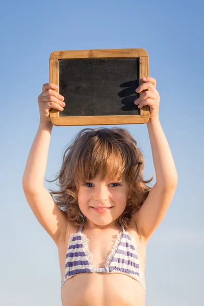 Criança feliz segurando quadro branco — Fotografia de Stock