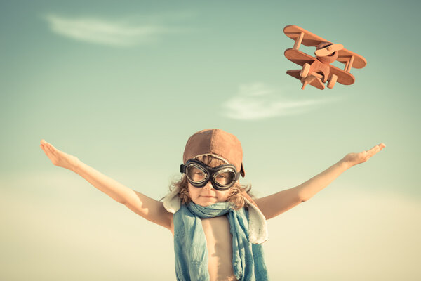 Happy kid playing with toy airplane