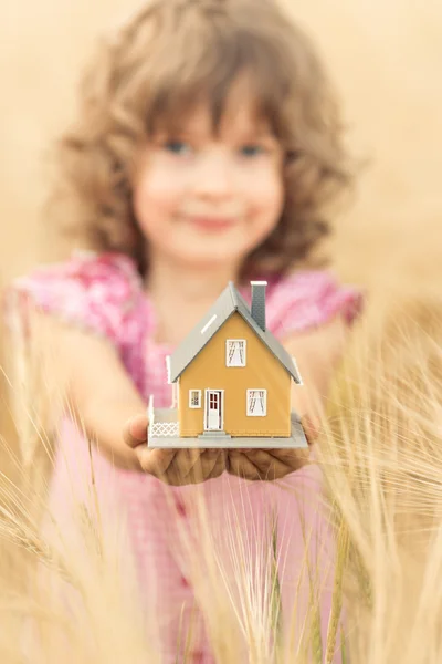 Criança segurando casa em mãos — Fotografia de Stock