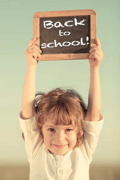 Niño de la escuela sosteniendo pizarra pequeña — Foto de Stock