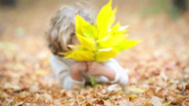 Mutlu çocuk sonbahar parkında dışarıda oynuyor.